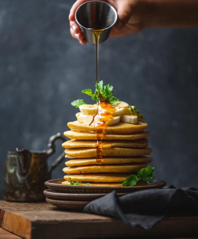 Stack of pancakes with syrup and fresh fruit