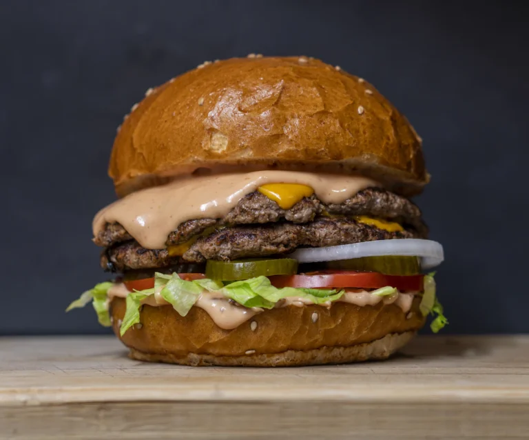 Juicy cheeseburger with lettuce and sauce on a brioche bun