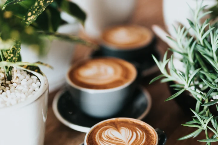 Cups of latte with foam art on a cafe table